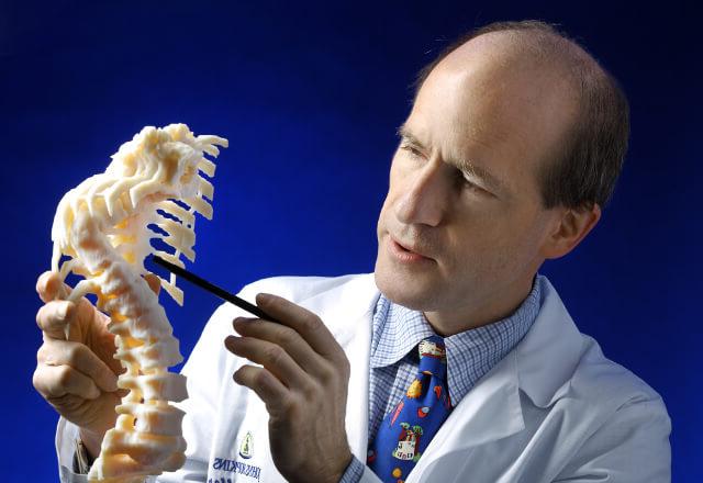 Dr. Sponsellor指着一个脊柱模型